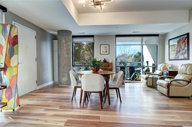 dining area featuring light hardwood / wood-style floors and a wall of windows