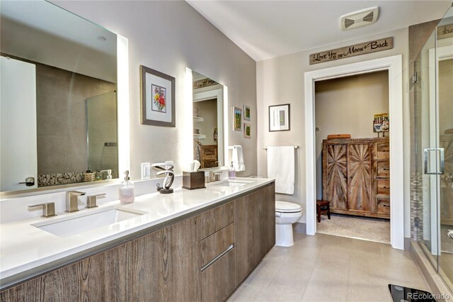 bathroom with tile patterned flooring, vanity, toilet, and walk in shower