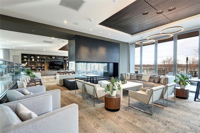 living room with a tray ceiling and light hardwood / wood-style flooring