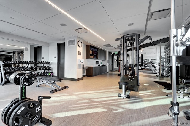 workout area featuring a paneled ceiling, baseboards, visible vents, and carpet flooring