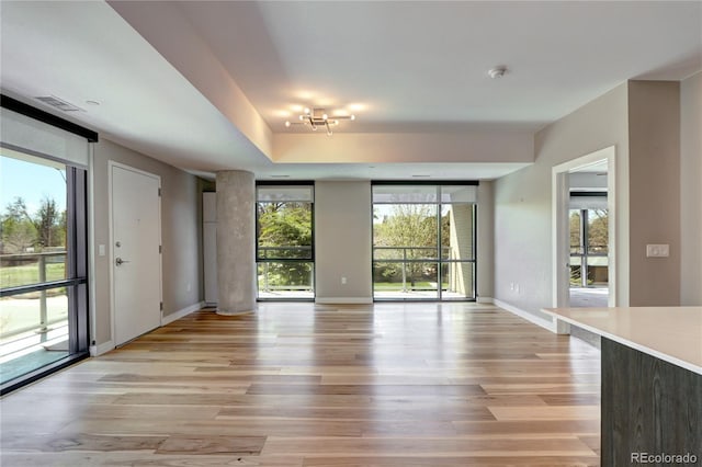 4200 W 17th Ave Unit 235, Denver, CO 80204 - unfurnished living room featuring baseboards, light wood-style flooring, and visible vents