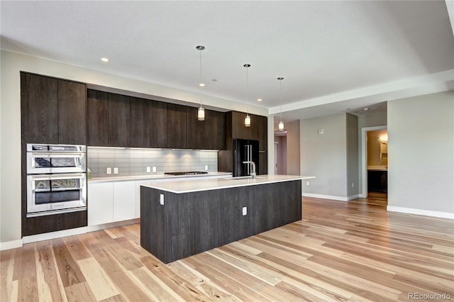 4200 W 17th Ave Unit 235, Denver, CO 80204 - kitchen with stainless steel appliances, modern cabinets, light wood finished floors, light countertops, and dark brown cabinets