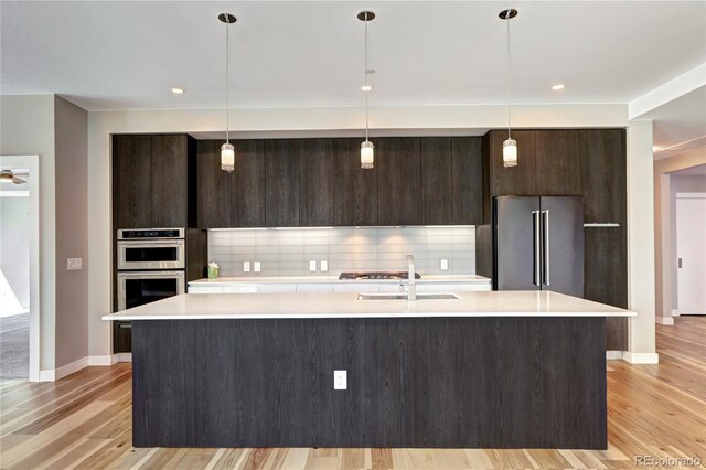 4200 W 17th Ave Unit 235, Denver, CO 80204 - kitchen featuring light countertops, stainless steel appliances, modern cabinets, and dark brown cabinets