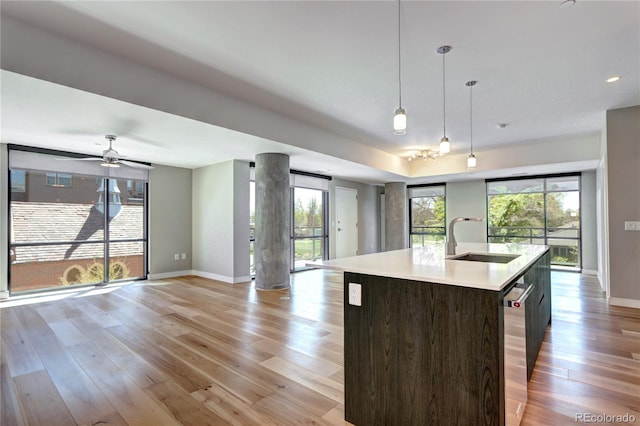 4200 W 17th Ave Unit 235, Denver, CO 80204 - kitchen featuring a sink, light wood-type flooring, open floor plan, and baseboards