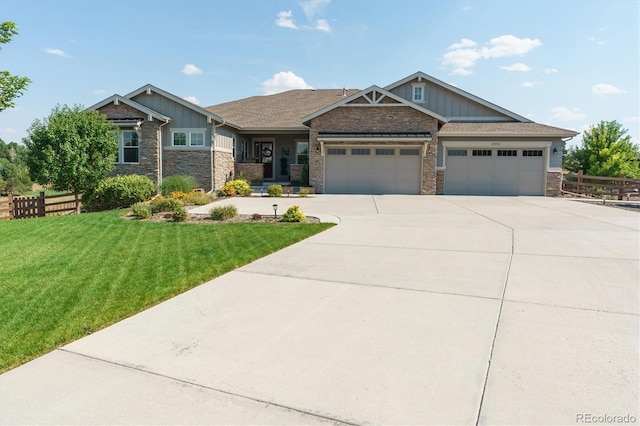 craftsman inspired home with a garage and a front lawn