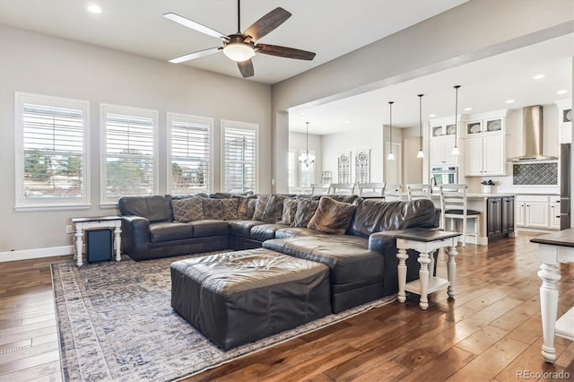 living room featuring dark hardwood / wood-style flooring and ceiling fan with notable chandelier