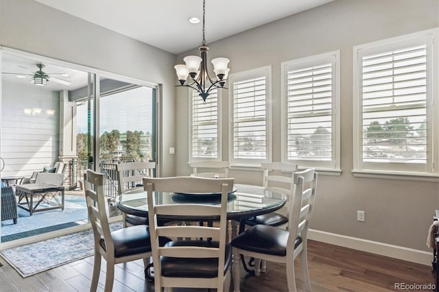 dining space featuring ceiling fan with notable chandelier and dark wood-type flooring