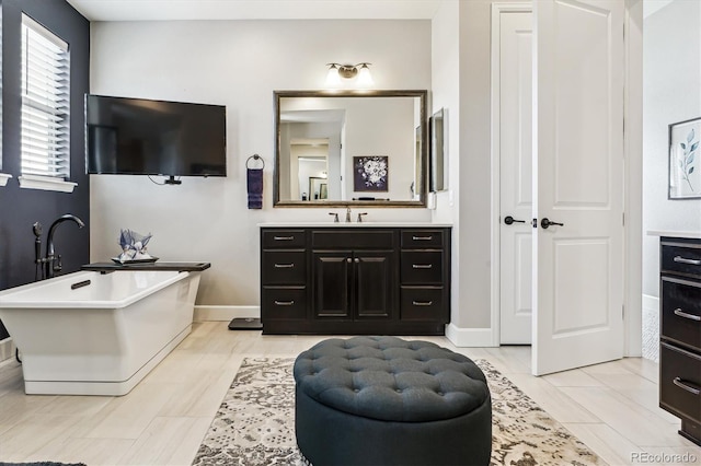 bathroom featuring vanity and a bath