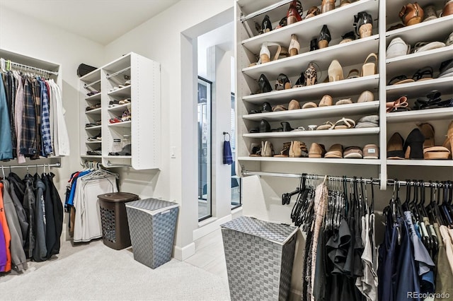 walk in closet featuring light colored carpet