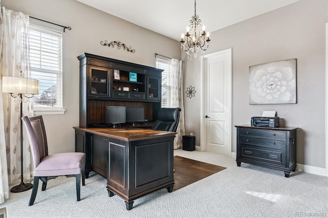 office with carpet floors, a wealth of natural light, and an inviting chandelier