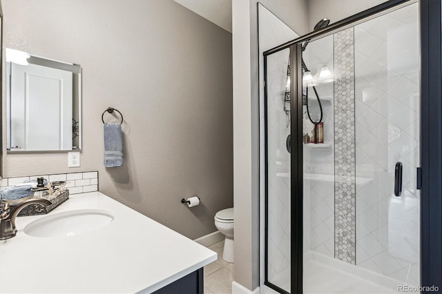 bathroom featuring tile patterned floors, vanity, toilet, and a shower with door