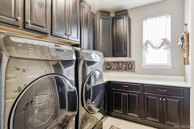 laundry room featuring cabinets, washer and dryer, and light tile patterned floors