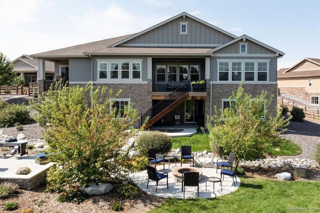 back of house with a fire pit and a patio