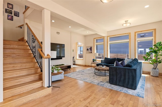 living area with light wood-type flooring, recessed lighting, baseboards, and stairs