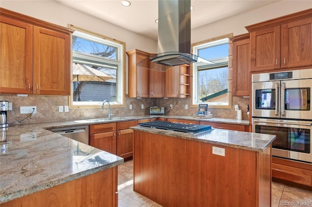 kitchen with appliances with stainless steel finishes, island range hood, a sink, and light tile patterned floors