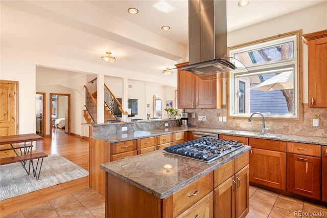kitchen with island range hood, a wealth of natural light, a kitchen island, and a sink