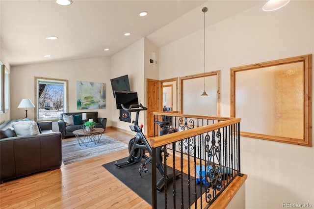 exercise area featuring wood finished floors, vaulted ceiling, and recessed lighting