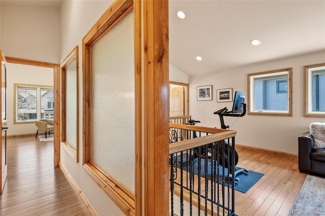 hall featuring baseboards, recessed lighting, hardwood / wood-style floors, and vaulted ceiling
