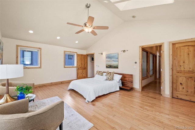 bedroom featuring high vaulted ceiling, recessed lighting, a skylight, light wood finished floors, and baseboards