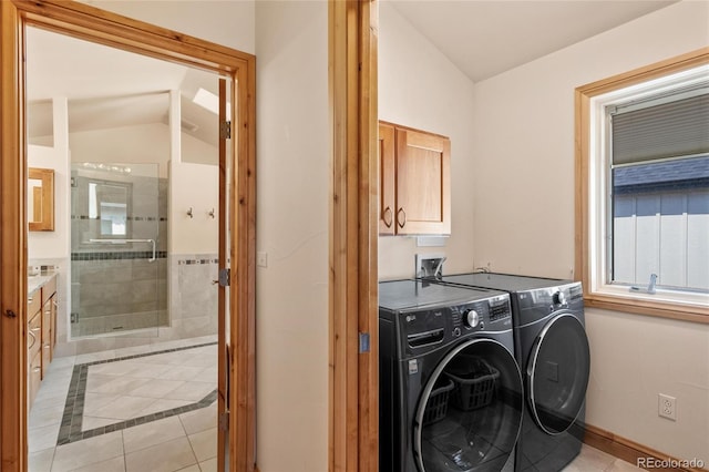 washroom featuring washer and dryer, light tile patterned floors, a wainscoted wall, and cabinet space