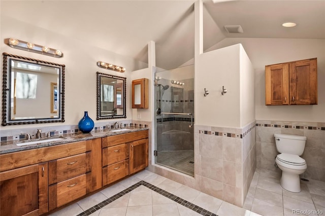 bathroom with toilet, tile patterned floors, a sink, and a stall shower