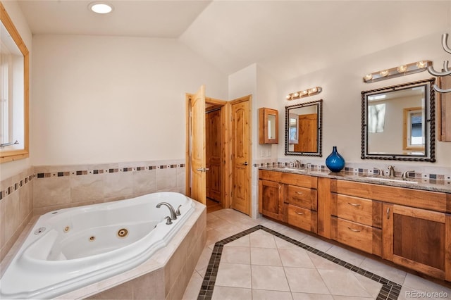 full bath with vaulted ceiling, a sink, a whirlpool tub, tile patterned floors, and double vanity