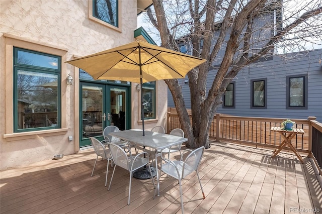 wooden terrace featuring french doors and outdoor dining space