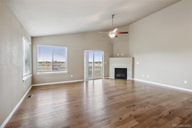 unfurnished living room with visible vents, a ceiling fan, baseboards, and wood finished floors