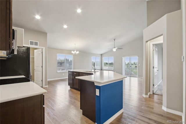kitchen featuring a sink, light countertops, dark brown cabinetry, and light wood-type flooring