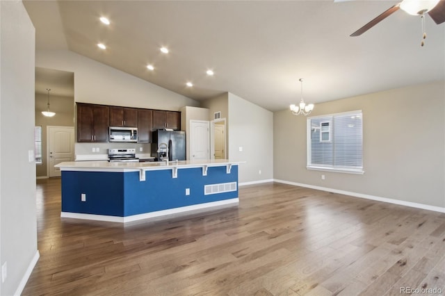 kitchen featuring dark brown cabinetry, visible vents, appliances with stainless steel finishes, a spacious island, and light countertops