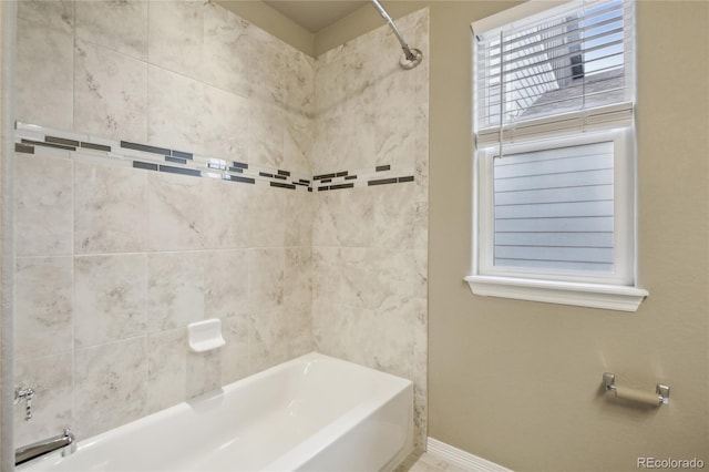 bathroom featuring baseboards and tub / shower combination