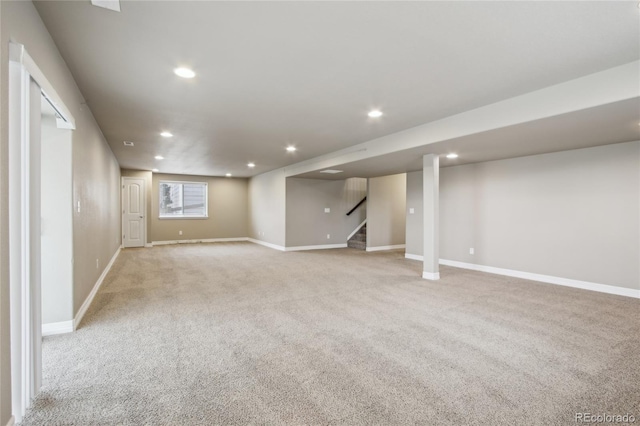finished below grade area with stairs, recessed lighting, baseboards, and light colored carpet