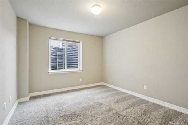 empty room featuring carpet floors and baseboards
