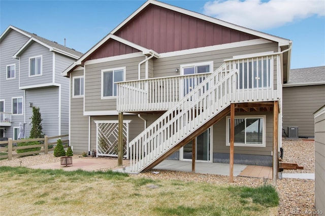 back of house with fence, stairs, a wooden deck, board and batten siding, and a patio area