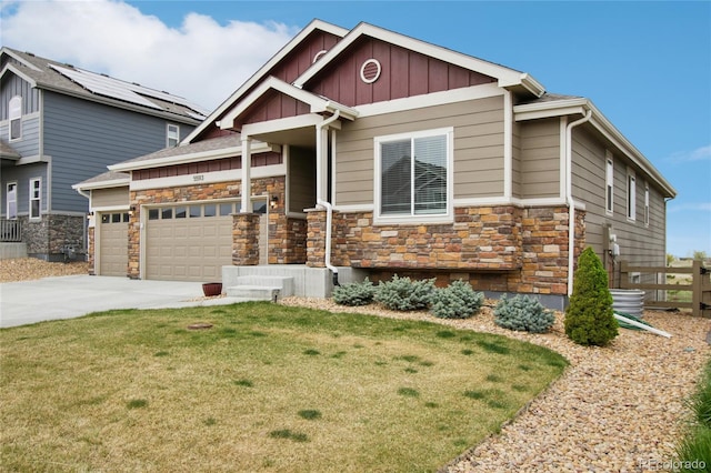 craftsman-style home with a garage, fence, a front yard, stone siding, and board and batten siding