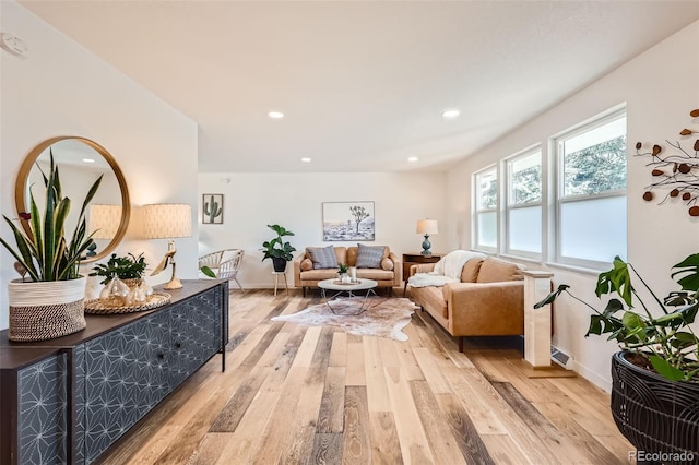 living room with recessed lighting, baseboards, visible vents, and light wood-style floors
