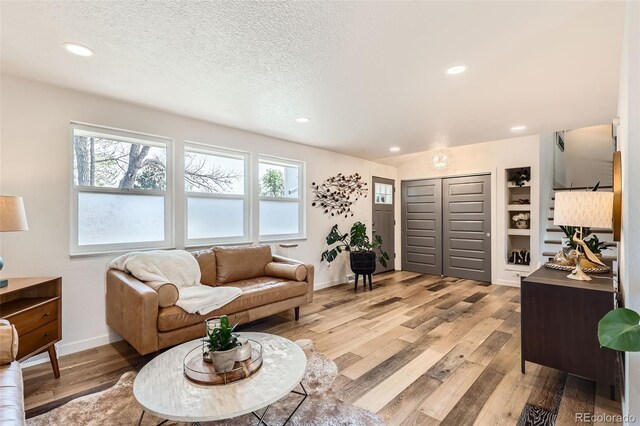 living area featuring recessed lighting, baseboards, light wood finished floors, and a wealth of natural light