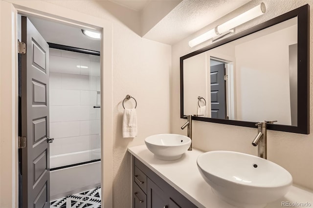 full bathroom with a sink, bath / shower combo with glass door, and double vanity
