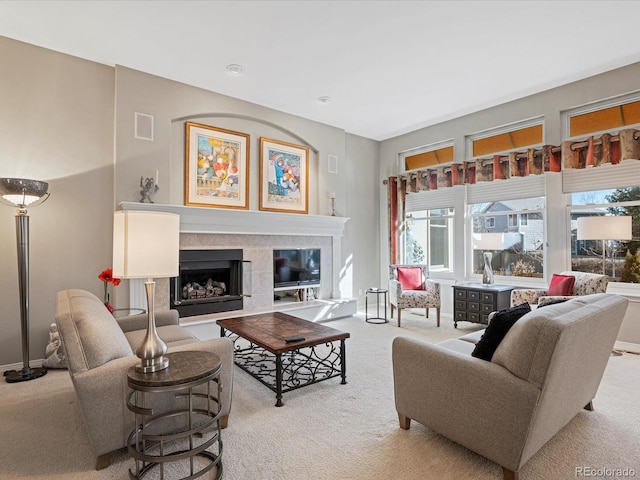 living room featuring a tiled fireplace and light colored carpet