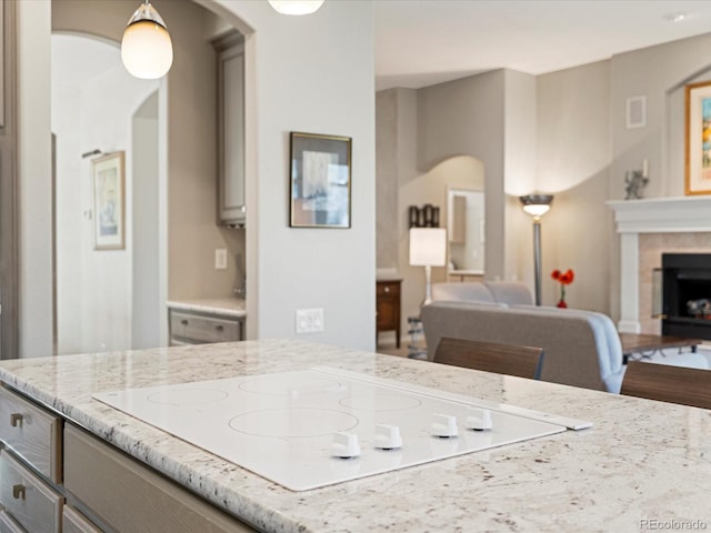 kitchen with light stone counters, white electric cooktop, and gray cabinetry