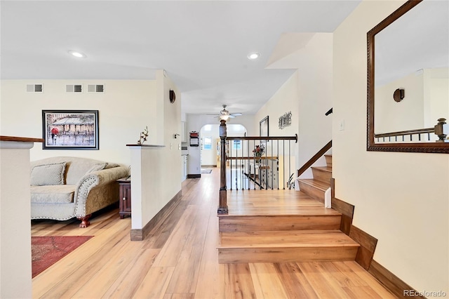 staircase featuring hardwood / wood-style floors and ceiling fan