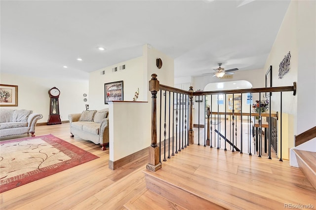 stairs featuring hardwood / wood-style floors and ceiling fan