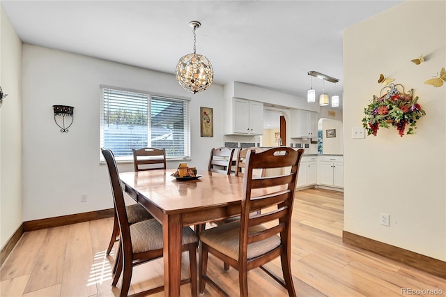 dining area with a chandelier and light wood-type flooring