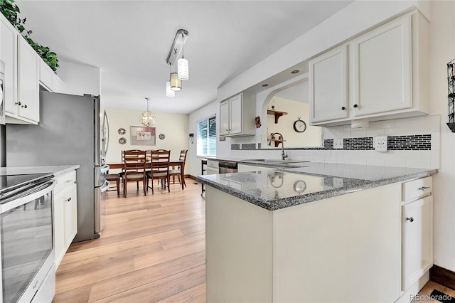 kitchen with sink, white cabinetry, hanging light fixtures, stainless steel electric range, and light hardwood / wood-style flooring