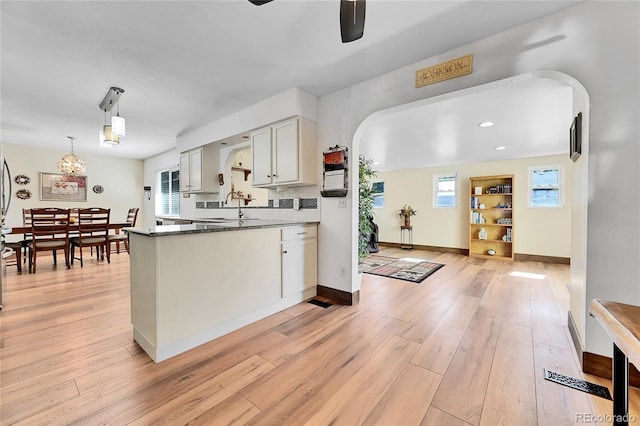 kitchen featuring white cabinetry, plenty of natural light, pendant lighting, and dark stone counters