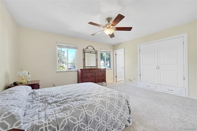 carpeted bedroom with ceiling fan and a closet