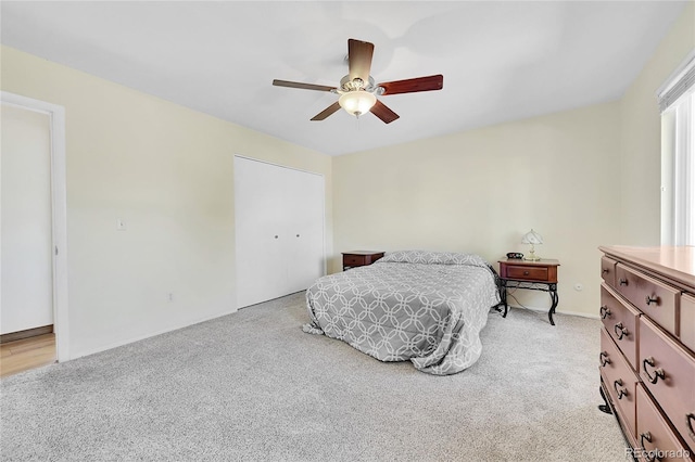 bedroom featuring light carpet, a closet, and ceiling fan