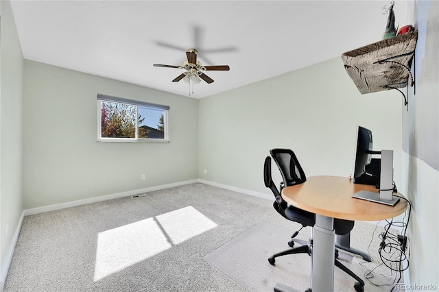 carpeted office space featuring ceiling fan