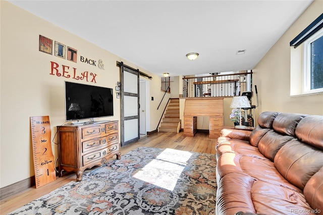 living room featuring light hardwood / wood-style flooring and a barn door