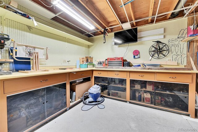 miscellaneous room featuring a workshop area and concrete floors